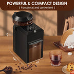 Black coffee grinder on a wooden table with coffee beans and a glass of coffee.