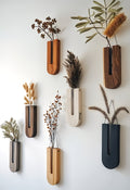 Set of wall-mounted planters with dried plants on a white wall