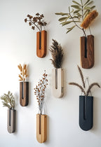 Set of wall-mounted planters with dried plants on a white wall
