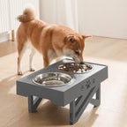 Dog eating from a raised pet bowl on a wooden floor.