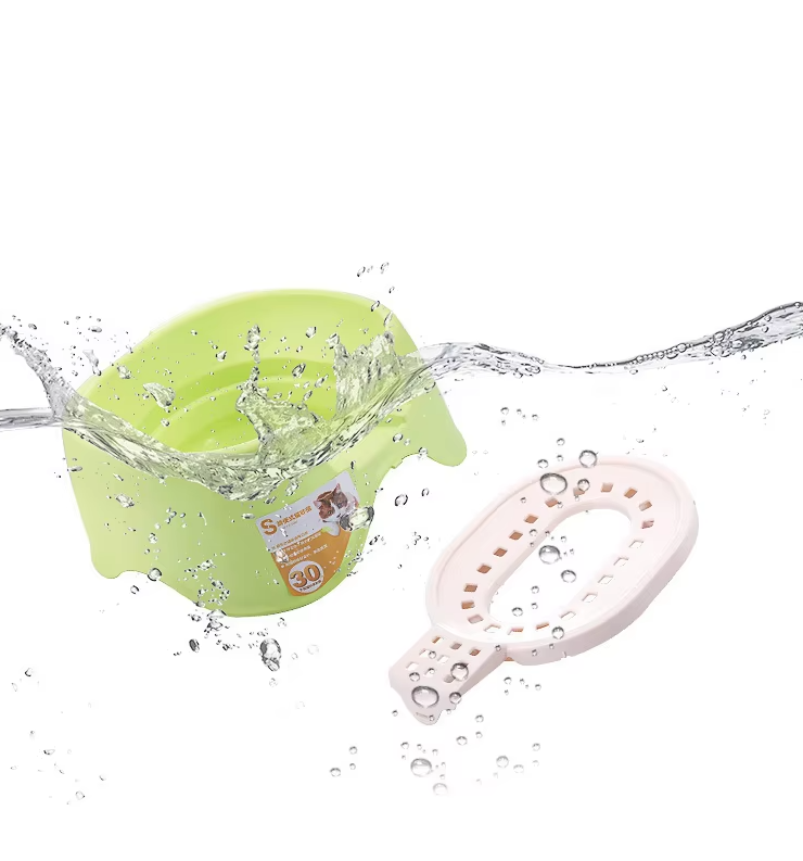 Green toy with water splashes and a pink tool on a white background