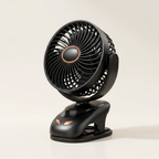 Black clip-on fan on a light beige background