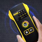 Hand holding a yellow and black electronic device with a digital display on a dark background