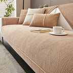 Beige sofa with cushions and a cup on a saucer in a living room setting.