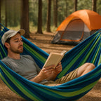 Man reading a book in a hammock with a tent in the background