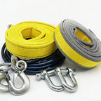 Two rolls of yellow and gray towing straps with metal hooks on a white background