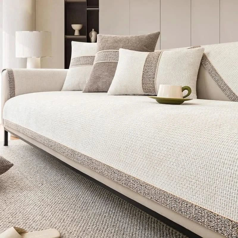 Beige sofa with patterned cushions and a cup on a coffee table in a living room setting.