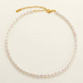 Pearl necklace with a gold clasp on a light beige background