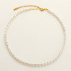 Pearl necklace with a gold clasp on a light beige background