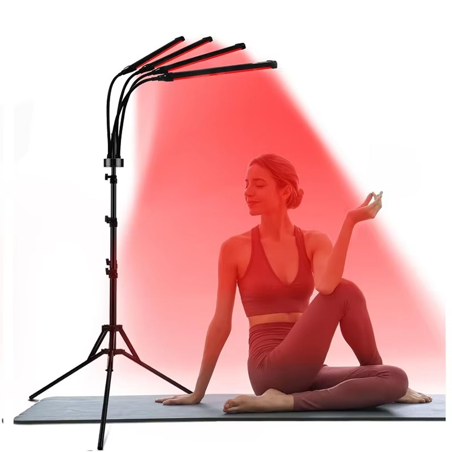 Woman in a yoga pose with a red light therapy lamp on a white background