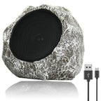 Rustic stone-style outdoor speaker with USB cable on a white background