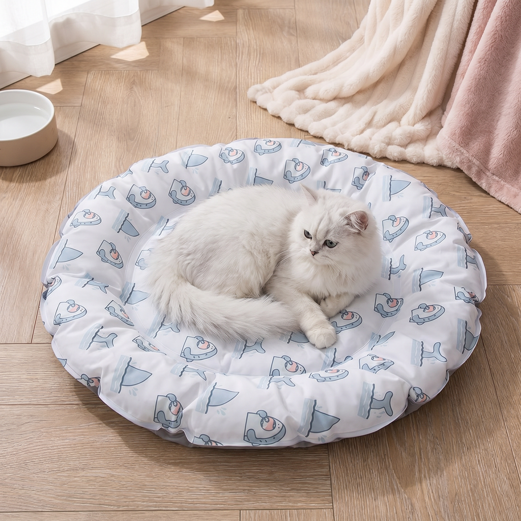 White cat lying on a round, patterned pet bed on a wooden floor.