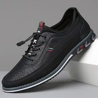 Black leather shoe with brand logo on a gray background
