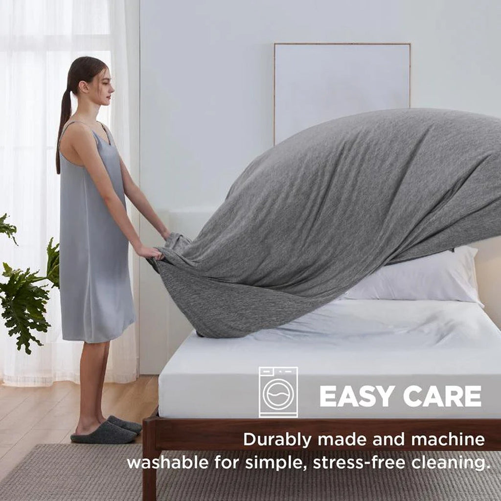 Woman adjusting a fitted sheet on a bed with text about easy care properties.