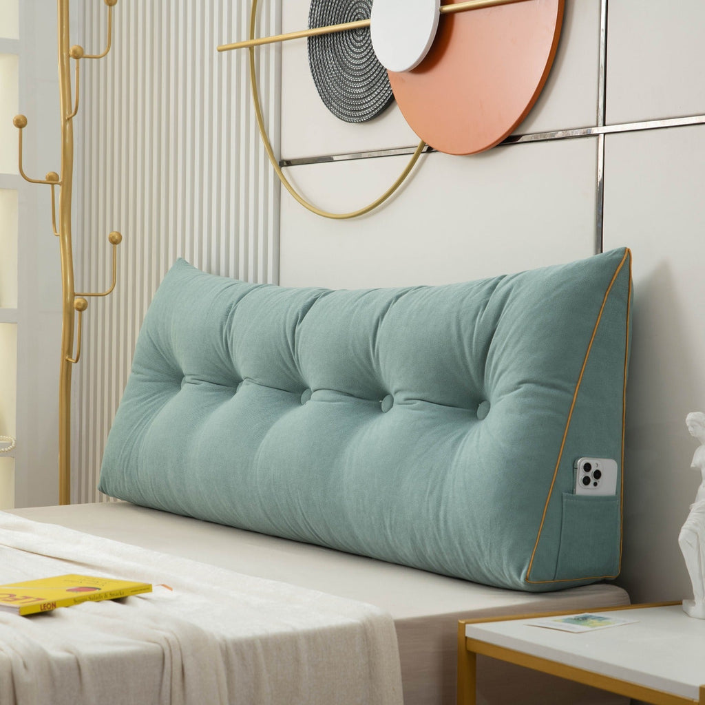 Teal tufted headboard pillow on a bed with decorative elements in the background