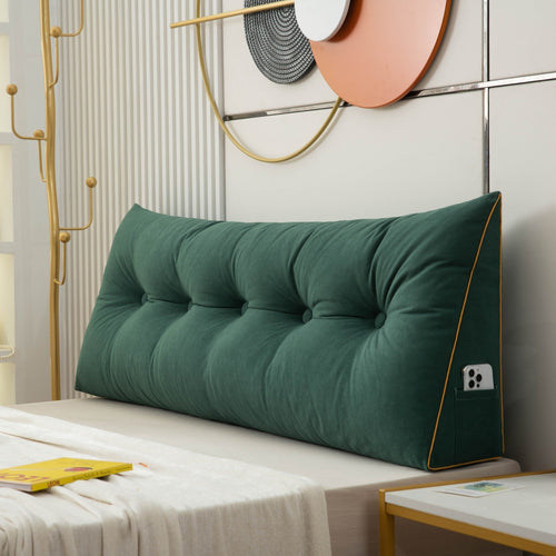 Green tufted headboard pillow on a bed with decorative wall art in the background