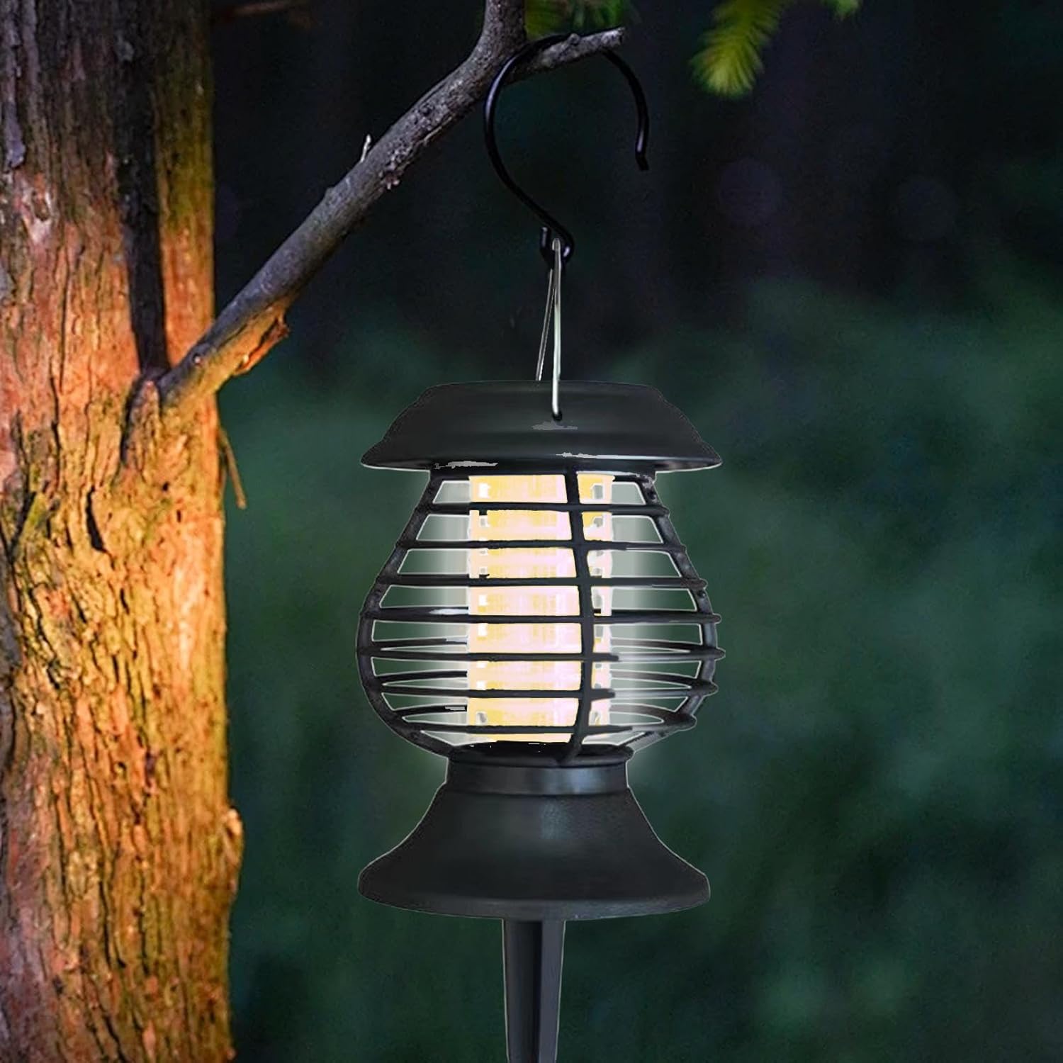 Solar-powered outdoor lantern hanging from a tree branch with a blurred natural background