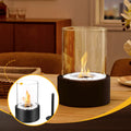 Tabletop fire pit with glass cover on a wooden surface, surrounded by a cozy indoor setting.