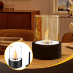 Tabletop fire pit with glass cover on a wooden surface, surrounded by a cozy indoor setting.