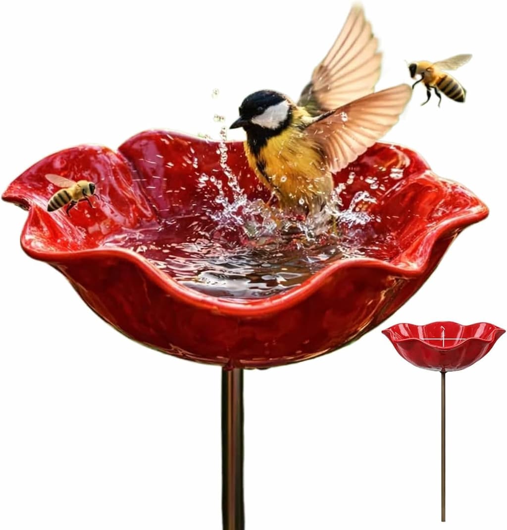 Red bird bath with a bird splashing in it and bees around on a white background