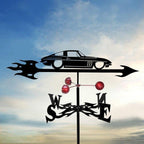 Decorative weathervane with car design against a cloudy sky