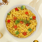 Pasta dish with vegetables in a white bowl on a light background