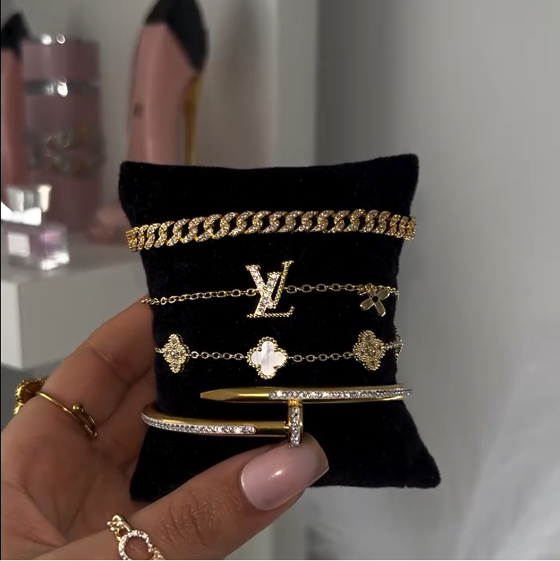 Gold jewelry displayed on a black cushion with a blurred background