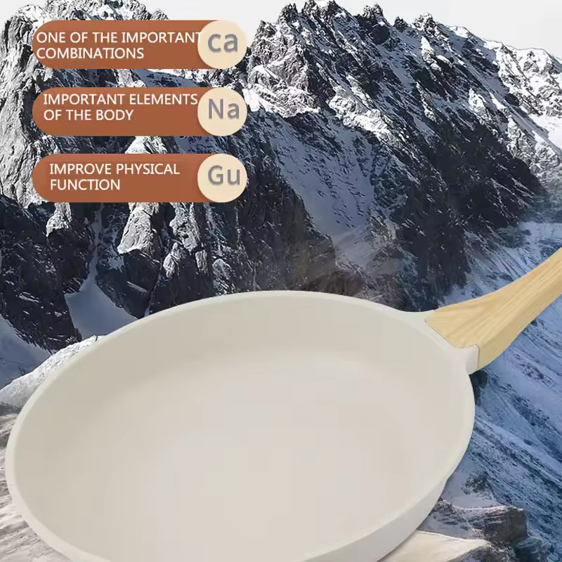 White frying pan with wooden handle against a mountainous background