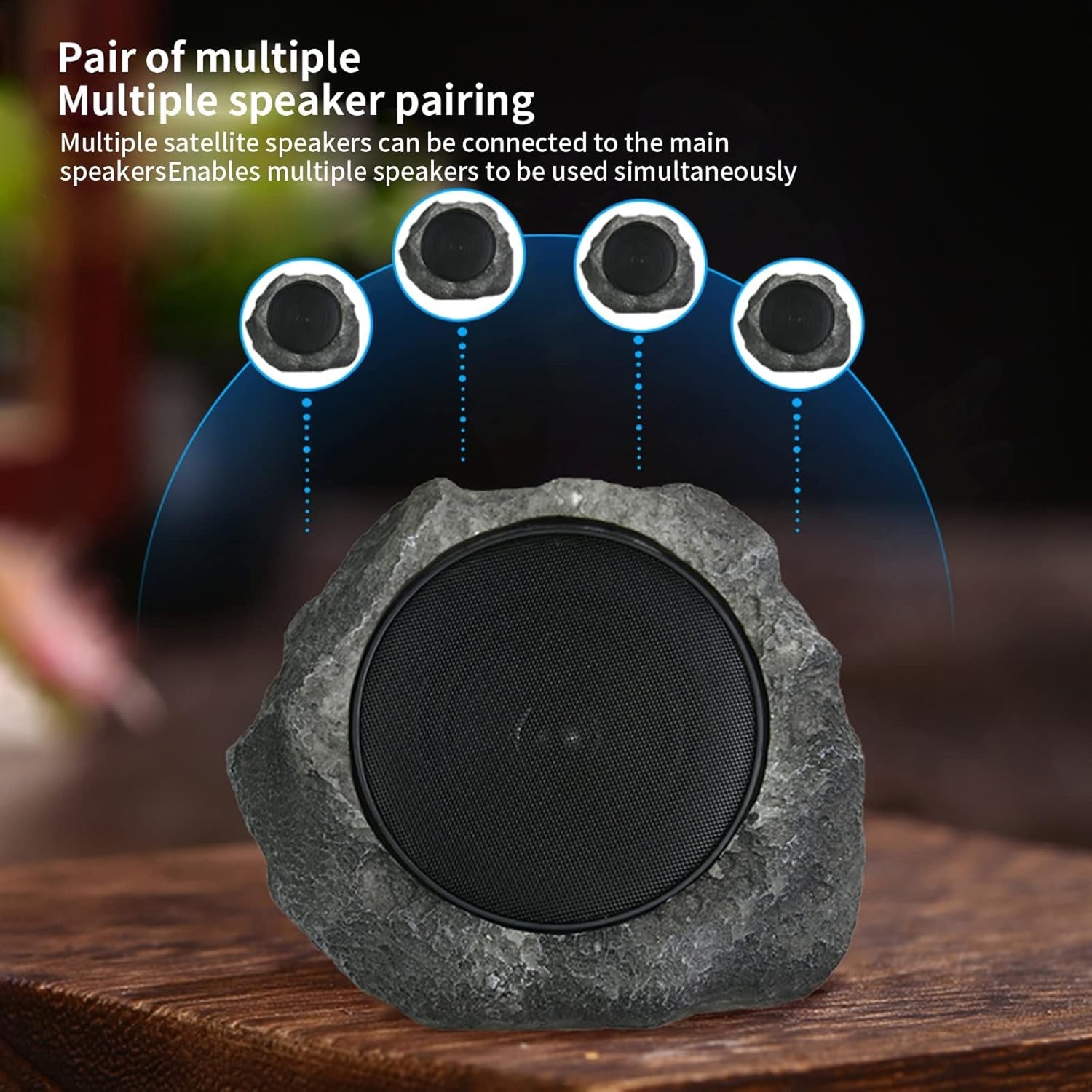 Rock-style speaker with multiple satellite speakers on a wooden surface