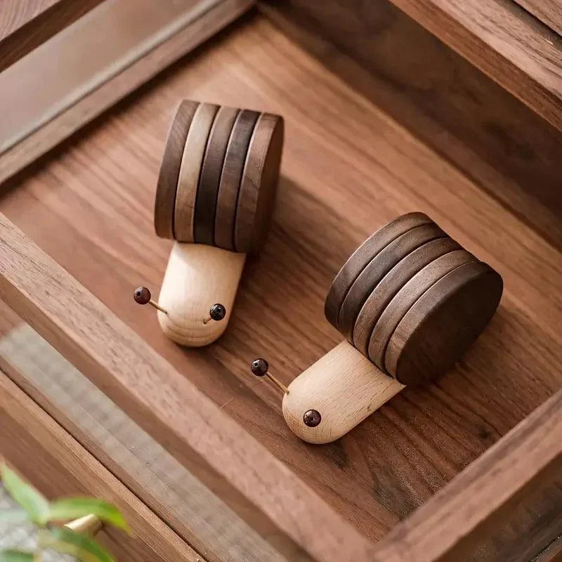 Two wooden caterpillar toys on a wooden surface