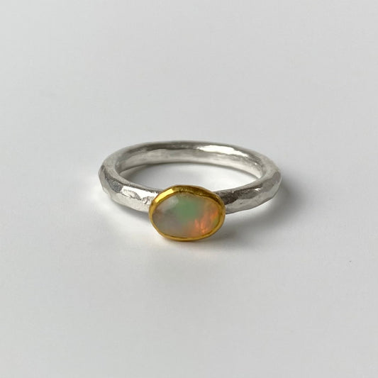 Silver Handcrafted ring with a 22ct gold accent and opal stone on a gray background