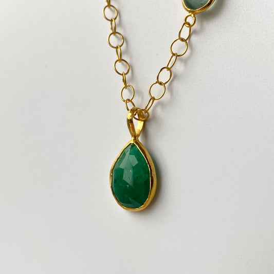 22ct Gold necklace with a green Peridot teardrop pendant on a light gray background