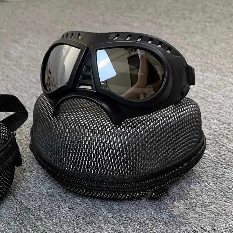 Black goggles with a textured carrying case on a gray surface