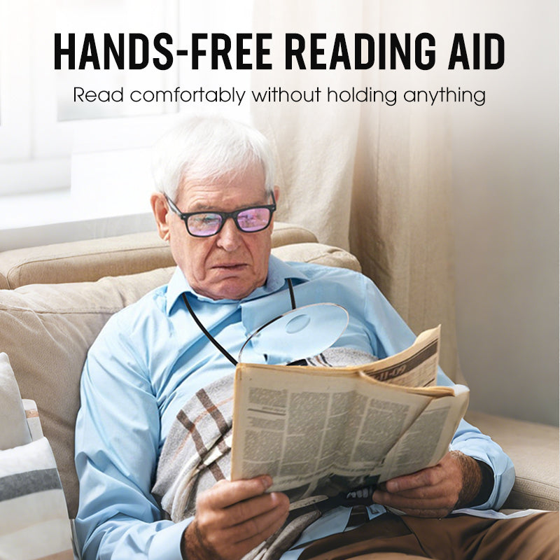 Man reading a newspaper with a hands-free reading aid, sitting on a couch.