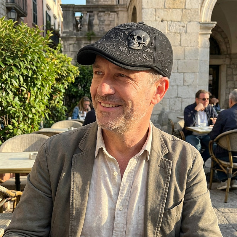 Man wearing a cap with a skull design outdoors in an urban setting