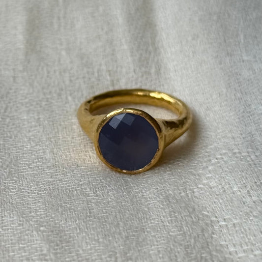 22ct Gold ring with a blue stone on a light gray fabric background