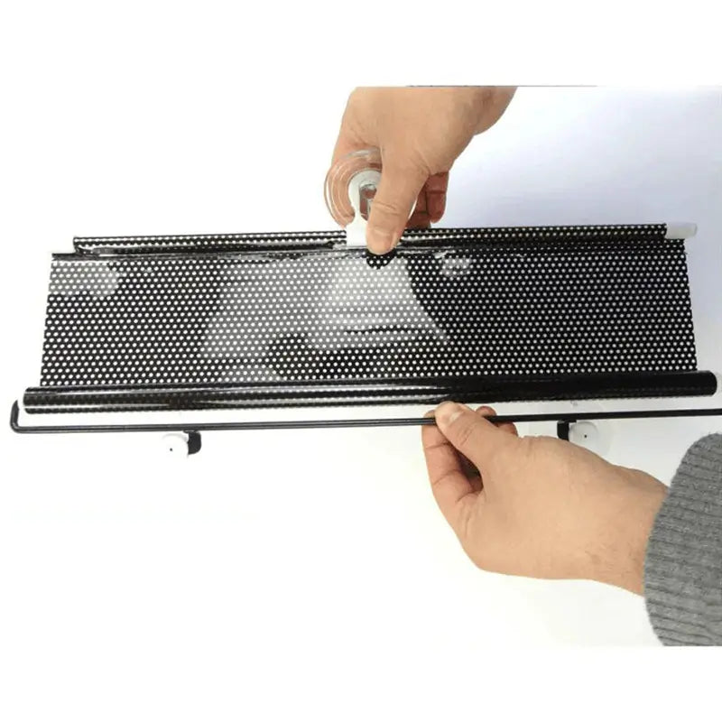 Person holding a black roller blind with a white background
