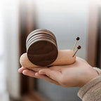 Wooden snail-shaped object held in a hand with a blurred background