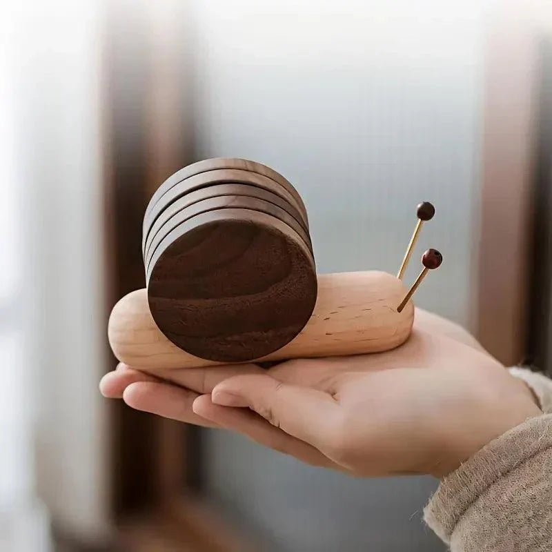 Wooden snail-shaped object held in a hand with a blurred background