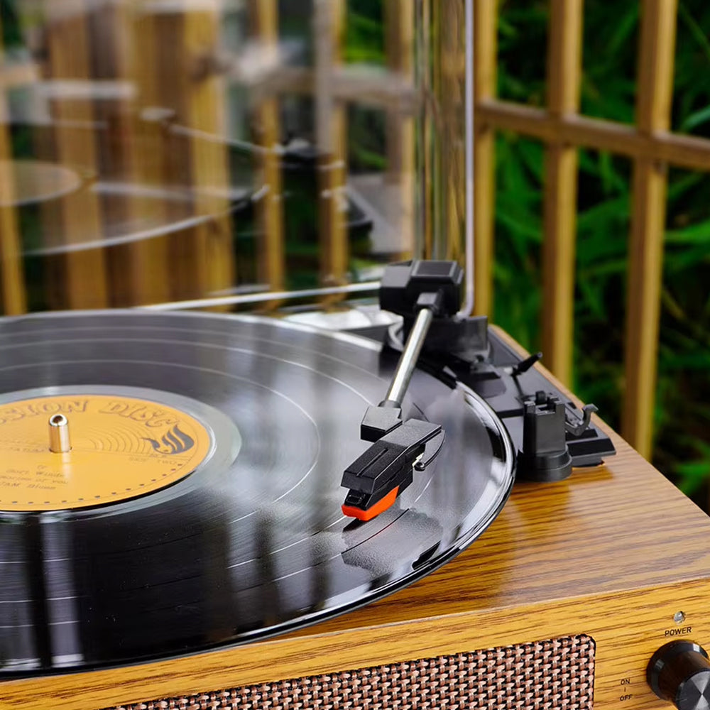 Turntable with a vinyl record on a wooden surface outdoors