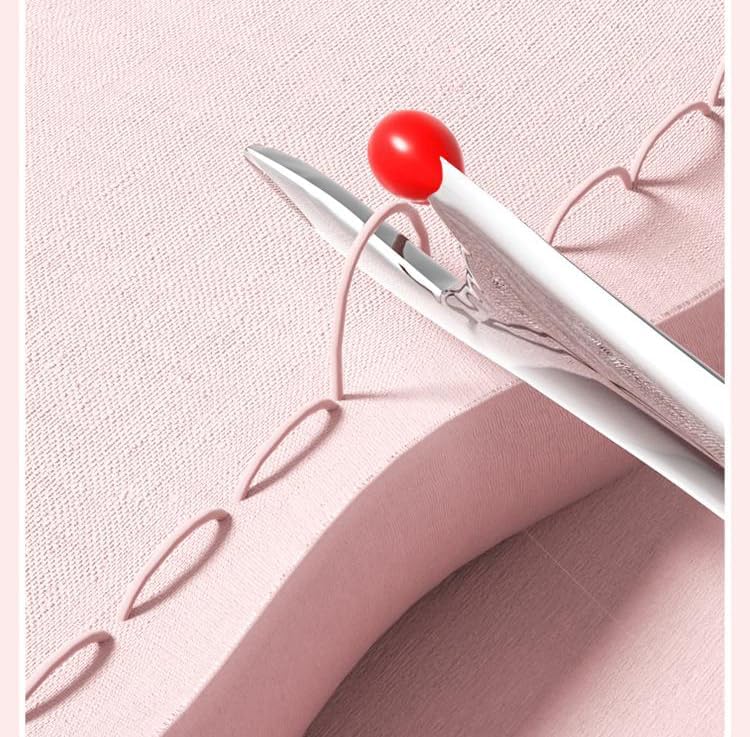 White pen with red cap on a pink fabric background