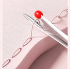 White pen with red cap on a pink fabric background