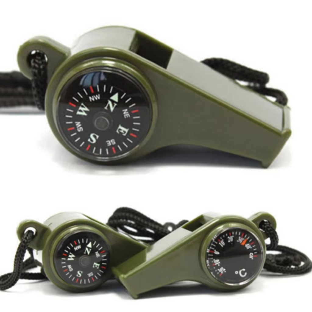 Green whistle with compass and thermometer on a white background