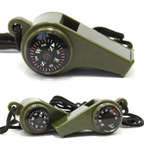 Green whistle with compass and thermometer on a white background