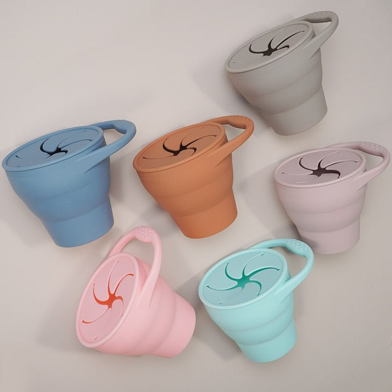 Set of colorful collapsible cups with dragon designs on a light gray background