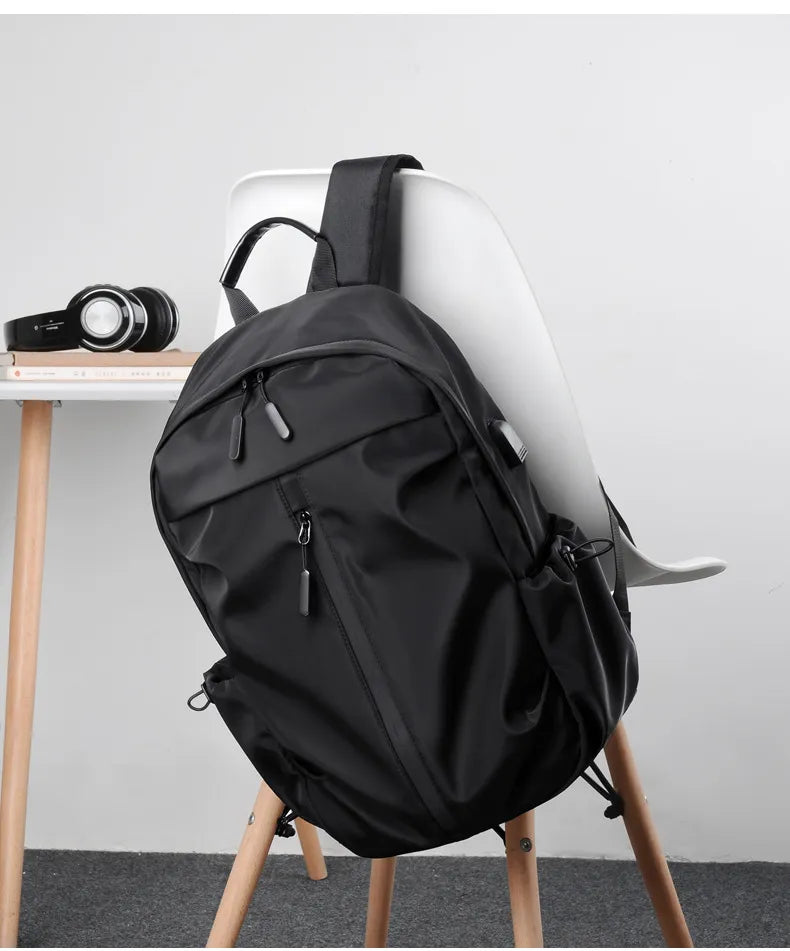 Black backpack on a chair with a minimal background