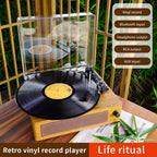 Retro vinyl record player with a vinyl record on a wooden surface, surrounded by greenery.