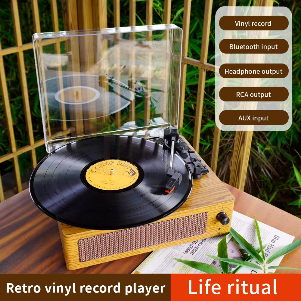 Retro vinyl record player with a vinyl record on a wooden surface, surrounded by greenery.