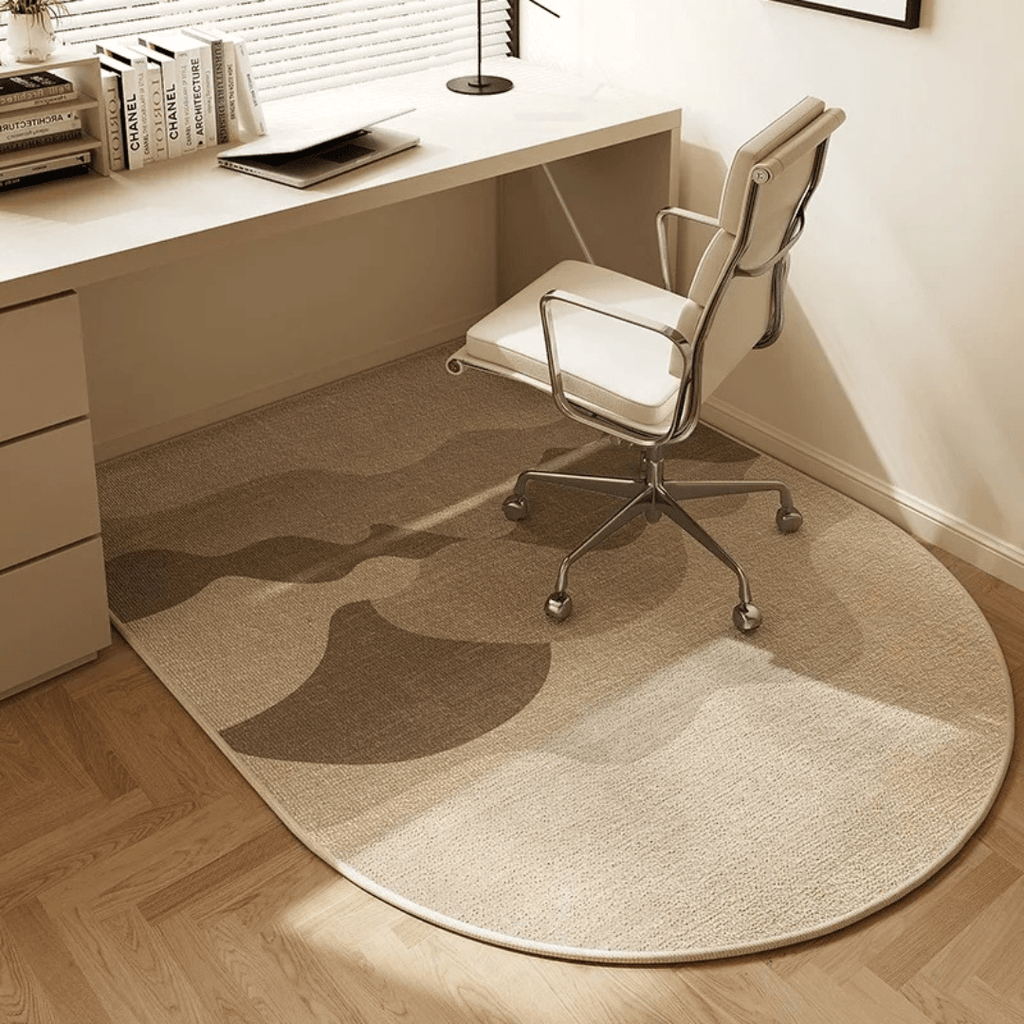 Beige round rug on a wooden floor in front of a desk with a chair.
