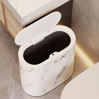 White marble-patterned trash bin on a bathroom floor